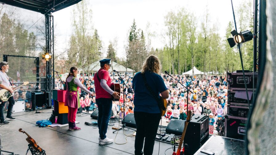 Orkesteri soittaa lavalla ja sen edessä on yleisöä